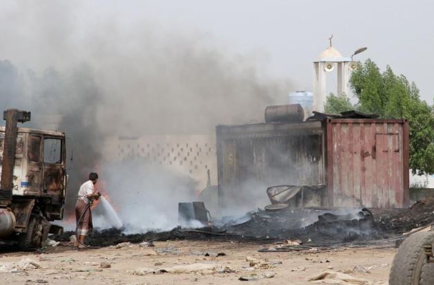 شخص يخمد حريقا نشب إثر اشتباكات في عدن اليمنية يوم الجمعة. تصوير: فواز سلمان - رويترز